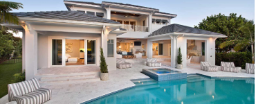 A large pool and patio area with furniture.